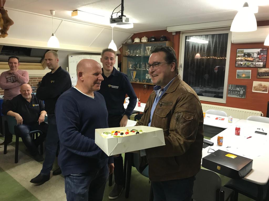 Foto 1: Willem Keuken overhandigd brandweerkorps Dodewaard een taart